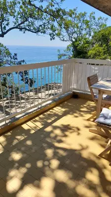 a balcony with a table and chairs and the ocean at Apartments Perazica Do in Sveti Stefan