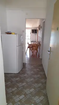 a kitchen with a white refrigerator and a table at Apartments Perazica Do in Sveti Stefan