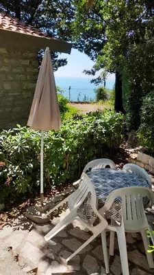 a table and chairs and an umbrella on a patio at Apartments Perazica Do in Sveti Stefan