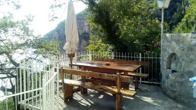 a wooden bench next to a fence with an umbrella at Apartments Perazica Do in Sveti Stefan