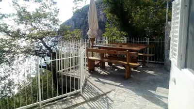 a wooden bench next to a fence with an umbrella at Apartments Perazica Do in Sveti Stefan