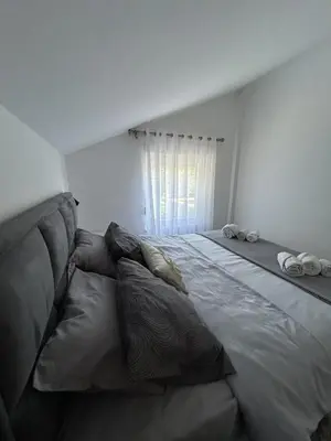 a large bed with pillows in a bedroom at Teodora Apartment in Kotor