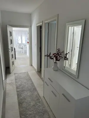 a white room with a dresser and a mirror at Teodora Apartment in Kotor