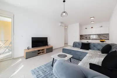a living room with a blue couch and a tv at MM Apartments Brown in Budva