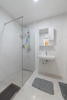 a white bathroom with a sink and a shower at MM Apartments Gray in Budva