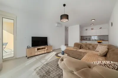 a living room with a couch and a flat screen tv at MM Apartments Gray in Budva
