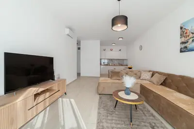 a living room with a couch and a television at MM Apartments Gray in Budva
