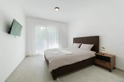 a bedroom with a large bed and a television at MM Apartments Gray in Budva