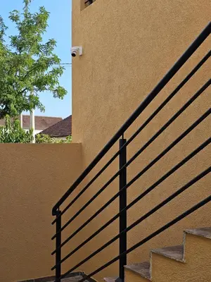 a black railing next to a building with a staircase at Airport apartments Jelena in Podgorica