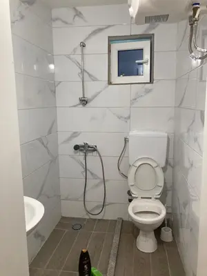 a white bathroom with a toilet and a sink at Kuća in Ulcinj