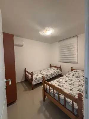 a bedroom with two beds and a window at Kuća in Ulcinj