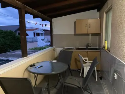 a small balcony with a table and chairs and a kitchen at Kuća in Ulcinj