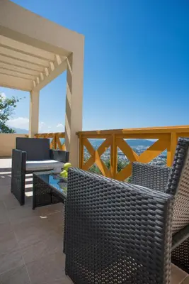 a patio with chairs and a table on a balcony at Berg Apartments in Bar
