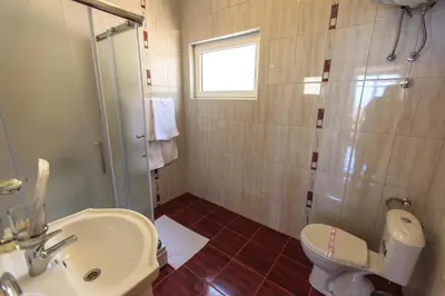 a bathroom with a sink and a toilet and a shower at Berg Apartments in Bar