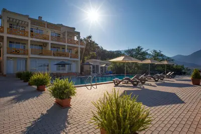a hotel with a pool and tables and chairs at Berg Apartments in Bar