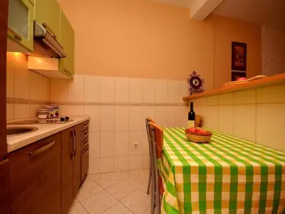 a kitchen with a table with a green and white table cloth at Apartment Susanj in Bar