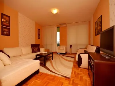a living room with a white couch and a tv at Apartment Susanj in Bar