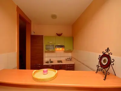 a kitchen with a wooden table with a hat on it at Apartment Susanj in Bar