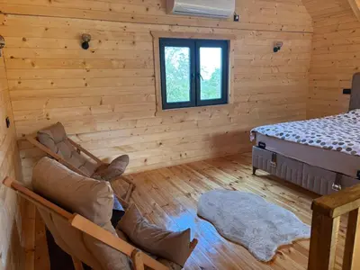 a log cabin with a bed and chairs in a room at Driftwood Dreams in Cetinje