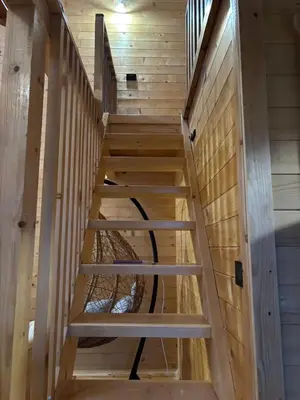 a staircase in a cabin with wooden walls at Driftwood Dreams in Cetinje
