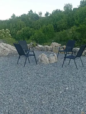 a couple of chairs sitting on top of a gravel field at Driftwood Dreams in Cetinje