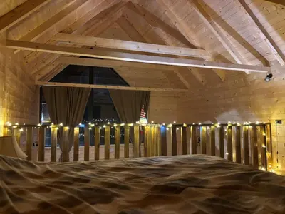 a room with a bed and a wooden ceiling with lights at Driftwood Dreams in Cetinje