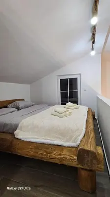 a bedroom with a large wooden bed in a room at LU House in Virpazar