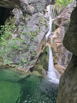 a waterfall on the side of a rocky cliff at LU House in Virpazar