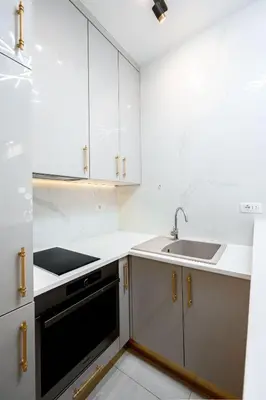 a kitchen with white cabinets and a sink at URBAN-Soho City Complex in Bar