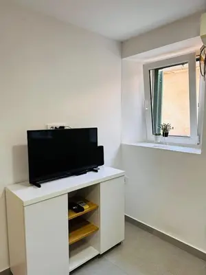 a living room with a tv on a white cabinet at 2 Charming Apartment in Kotor Old Town in Kotor