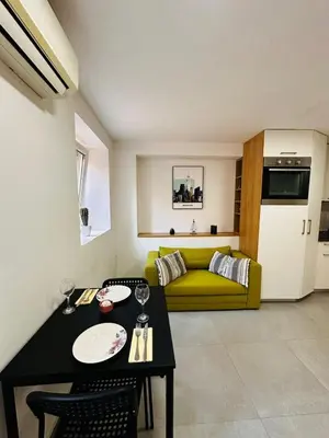 a living room with a table and a yellow couch at 2 Charming Apartment in Kotor Old Town in Kotor