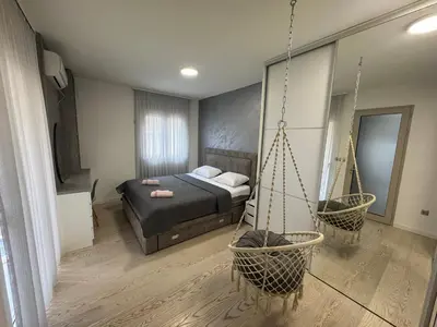 a bedroom with a bed and a hanging swing at Lux Apartment 14 in Kravlja