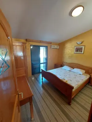 a bedroom with a bed and a wooden floor at Vidikovac in Utjeha