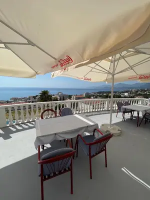a table and chairs with umbrellas on a roof at Vidikovac in Utjeha