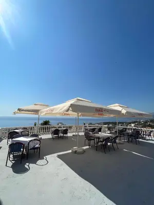a group of tables and chairs with umbrellas on the beach at Vidikovac in Utjeha