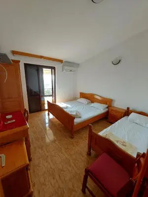 a bedroom with two beds and a table and a chair at Vidikovac in Utjeha
