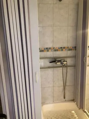 a bathroom with a shower with a hose in it at Apartmani Centar in Petrovac na Moru