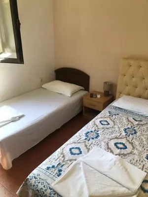 a bedroom with two beds and a table with a lamp at Apartmani Centar in Petrovac na Moru