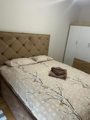 a bedroom with a bed with a bedspread with branches on it at Apartment Central point in Podgorica