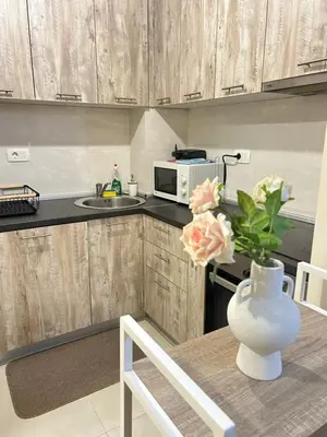 a kitchen with a table with a vase with flowers on it at Apartment Central point in Podgorica