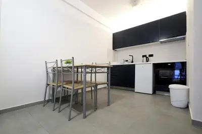 a kitchen with black cabinets and a table and chairs at Status-M Apartments Seoce17 in Budva