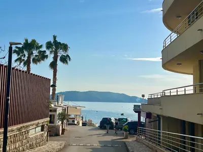 people walking down a street with a view of the water at Step to the sea apartment in Rafailovici
