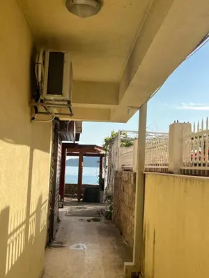 an alley with a tv on the side of a building at Step to the sea apartment in Rafailovici