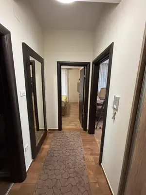 a hallway with four doors and a hallway with a mirror at Enjoy 1 Apartmani in Podgorica