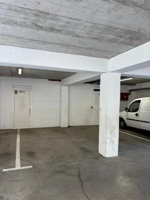 a parking garage with a white van parked in it at Enjoy 1 Apartmani in Podgorica