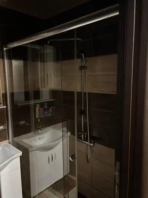 a bathroom with a glass shower with a sink at Enjoy 1 Apartmani in Podgorica