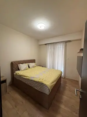 a bedroom with a bed in a room with a window at Enjoy 1 Apartmani in Podgorica
