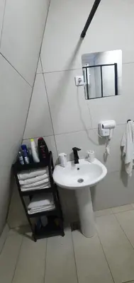 a white bathroom with a sink and a mirror at Cozzy LUX apartment near the Airport Podgorica in Lajkovići