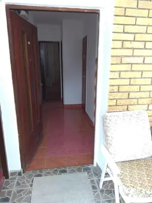 an open door to a room with a chair and a brick wall at Apartment M2 Pine tree Sutomore in Sutomore
