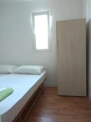 a bedroom with a bed with a window and a door at Apartment M2 Pine tree Sutomore in Sutomore